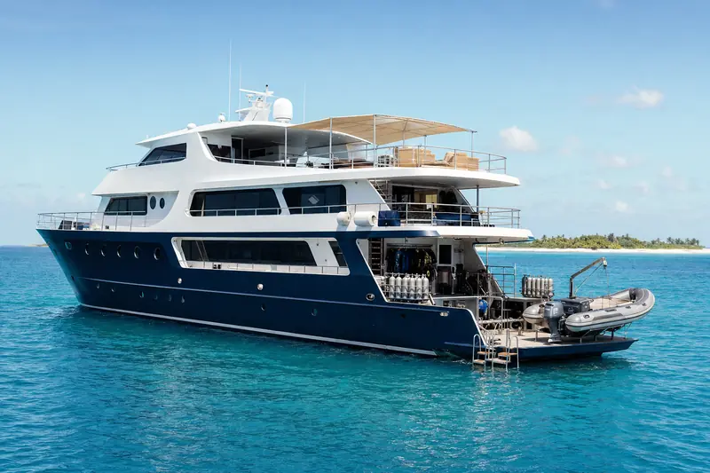 A liveaboard dive boat at anchor on clear tropical water