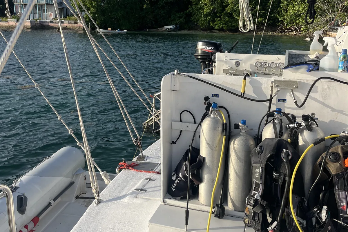 Scuba tanks and dive gear racked on a liveaboard dive deck